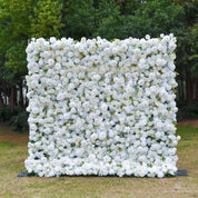 8*8ft floral wall made of white flowers in an outdoor setting with greenery.