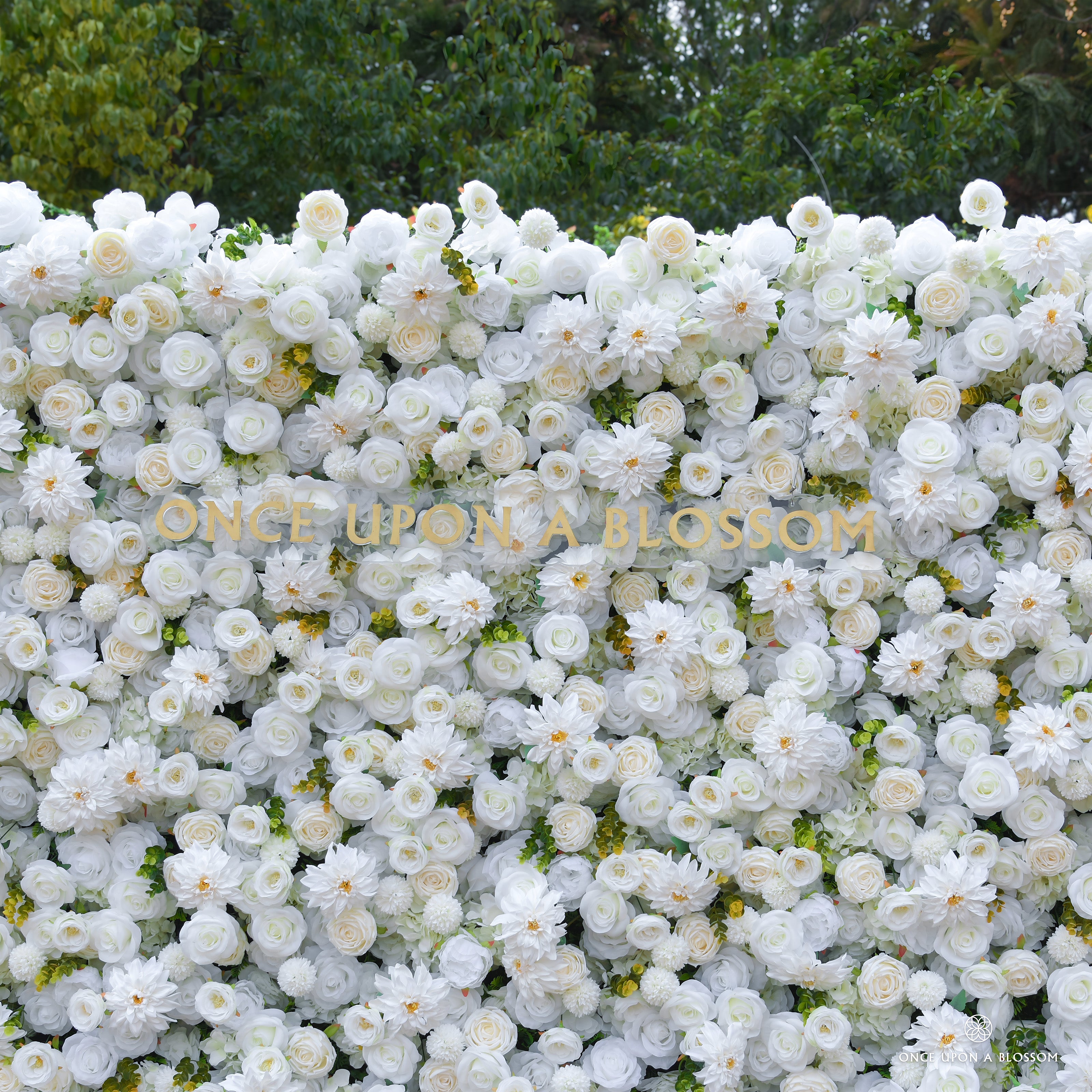 Wall of artificial flowers with 'Once Upon a Blossom' branding