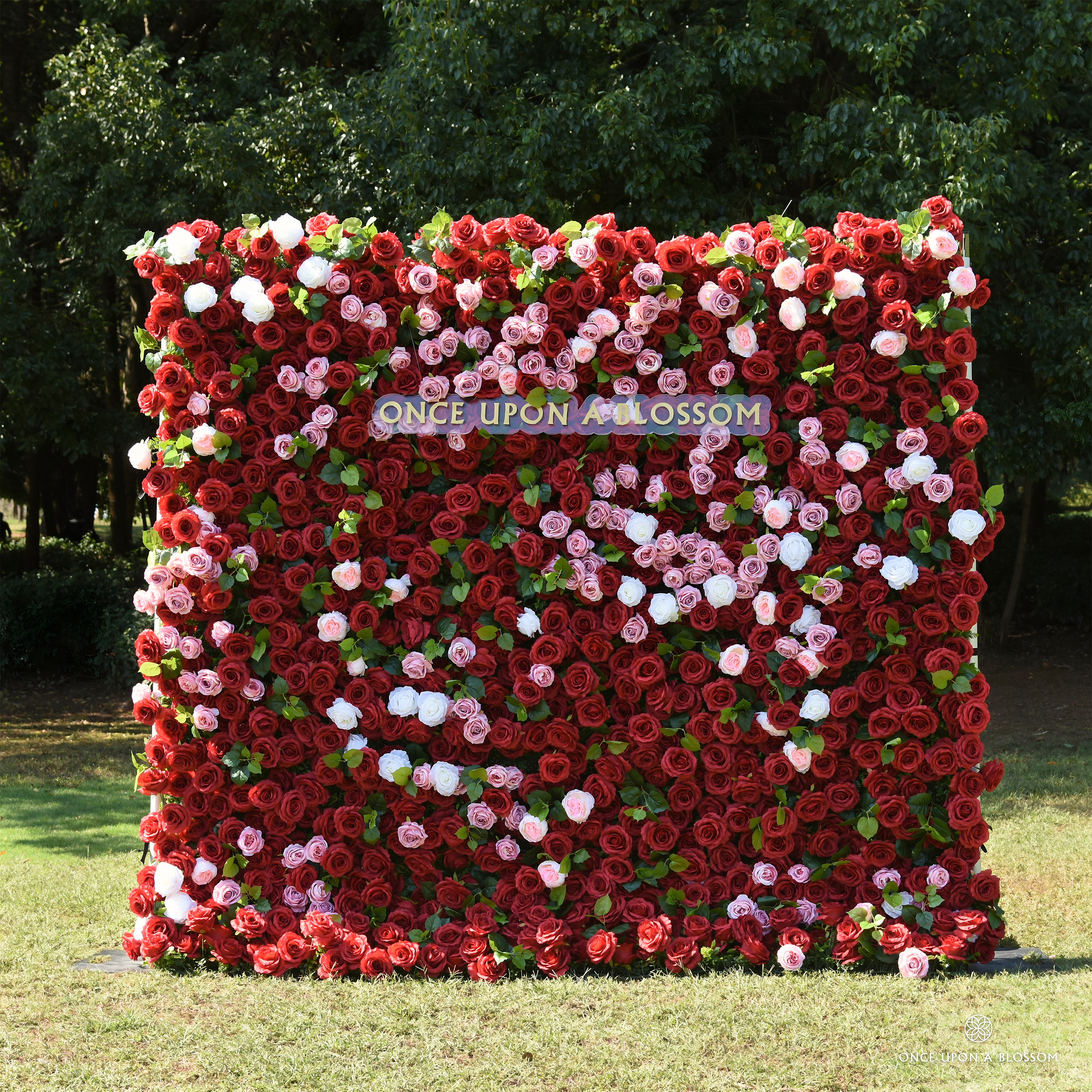 Front view of the Date Night red flower wall backdrop, deep red roses with pink and white accents, set outdoors