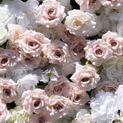 Petal-level close-up of dusty blush silk roses among white blooms on the First Blush flower wall backdrop
