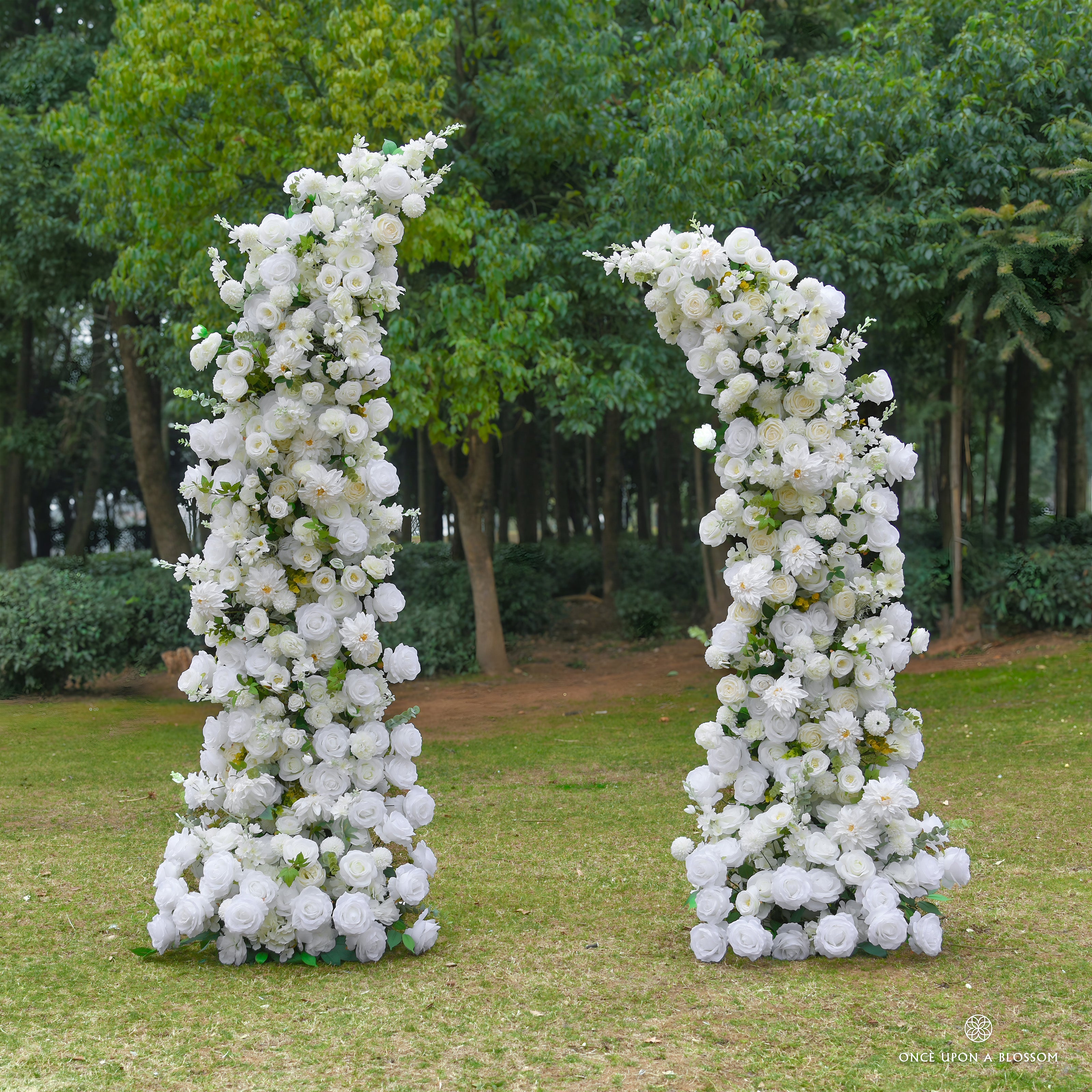 Two tall floral arches made of ivory flowers and greenery, made for weddings and ceremonies