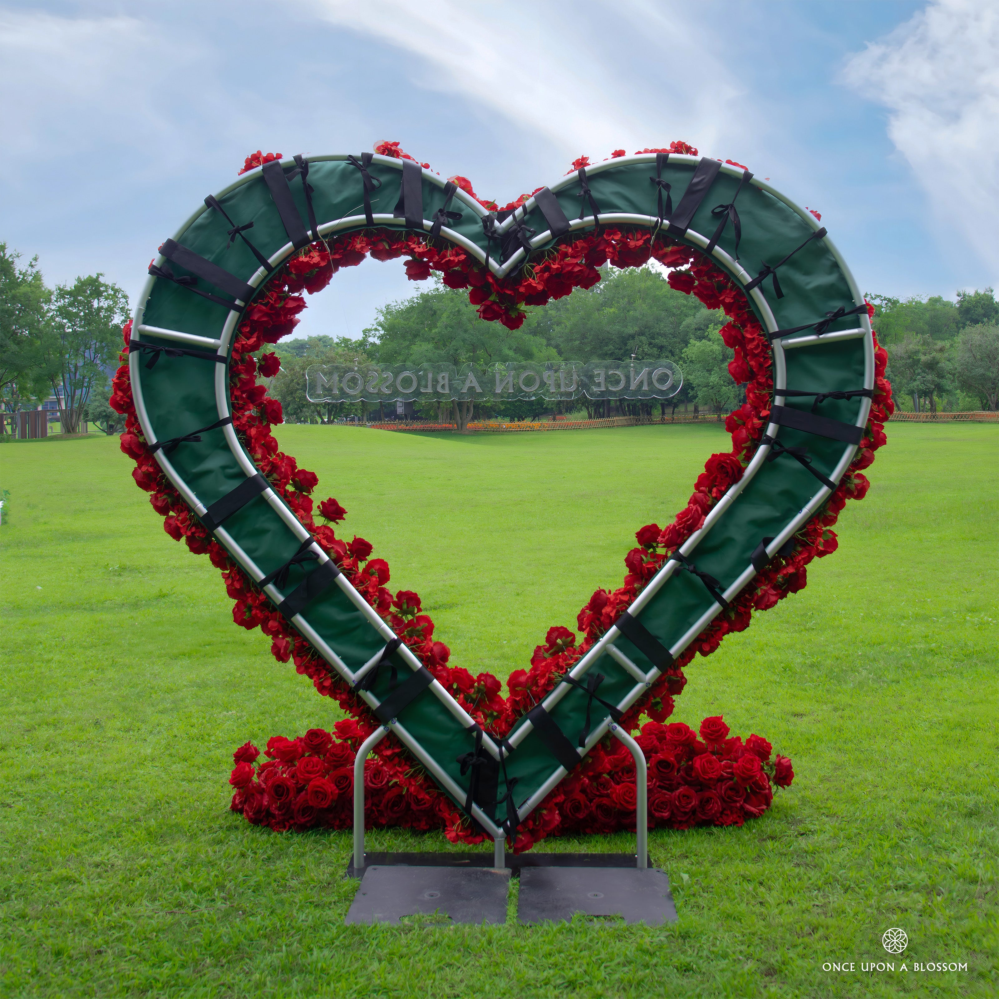 Back view of Pulse red flower arch showing construction details—fabric base with flowers attached, secured by straps and velcro.