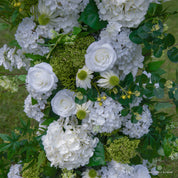 Detailed view of Be Here Now flower arch—greenery and white floral arrangement.