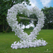 Left side of flower arch showing pure white roses and heart-shaped frame.