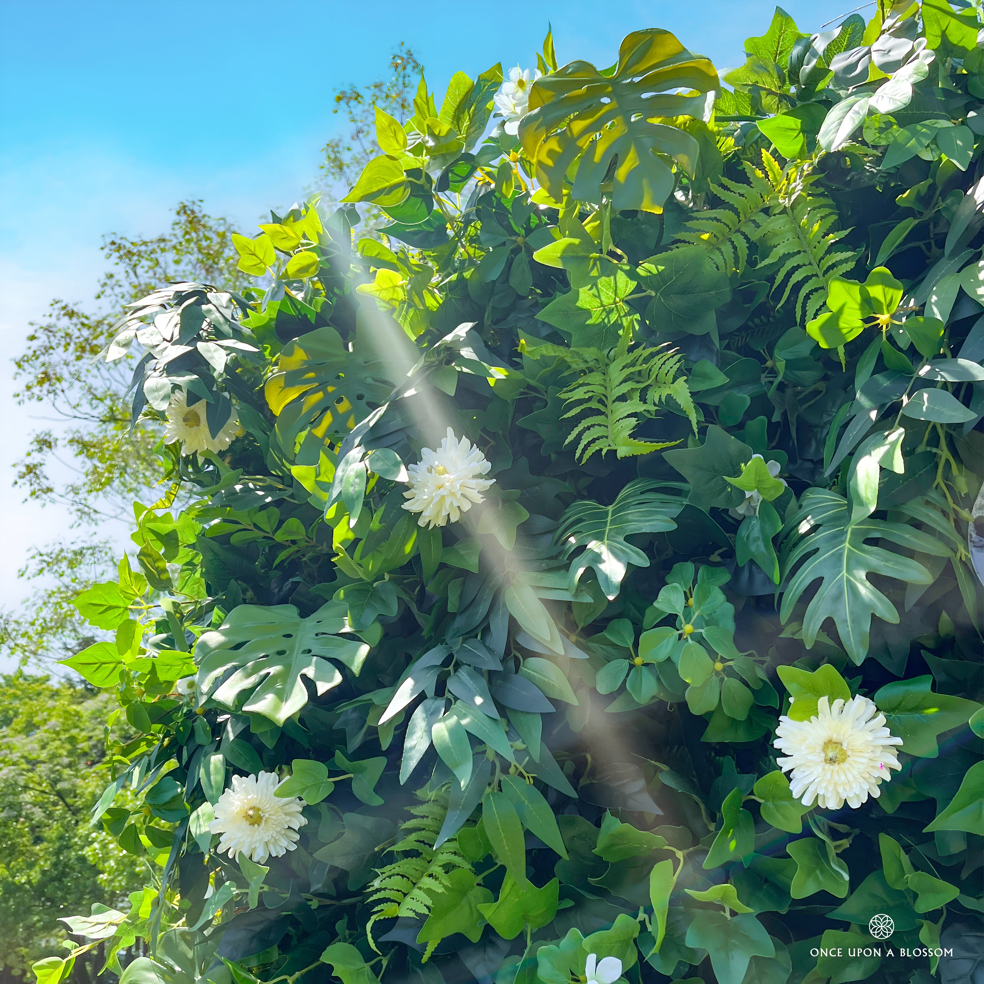 close-up of flower textures of greenery wall featuring chrysanthemums, pothos, and monstera leaves, from our Pearl Garden.