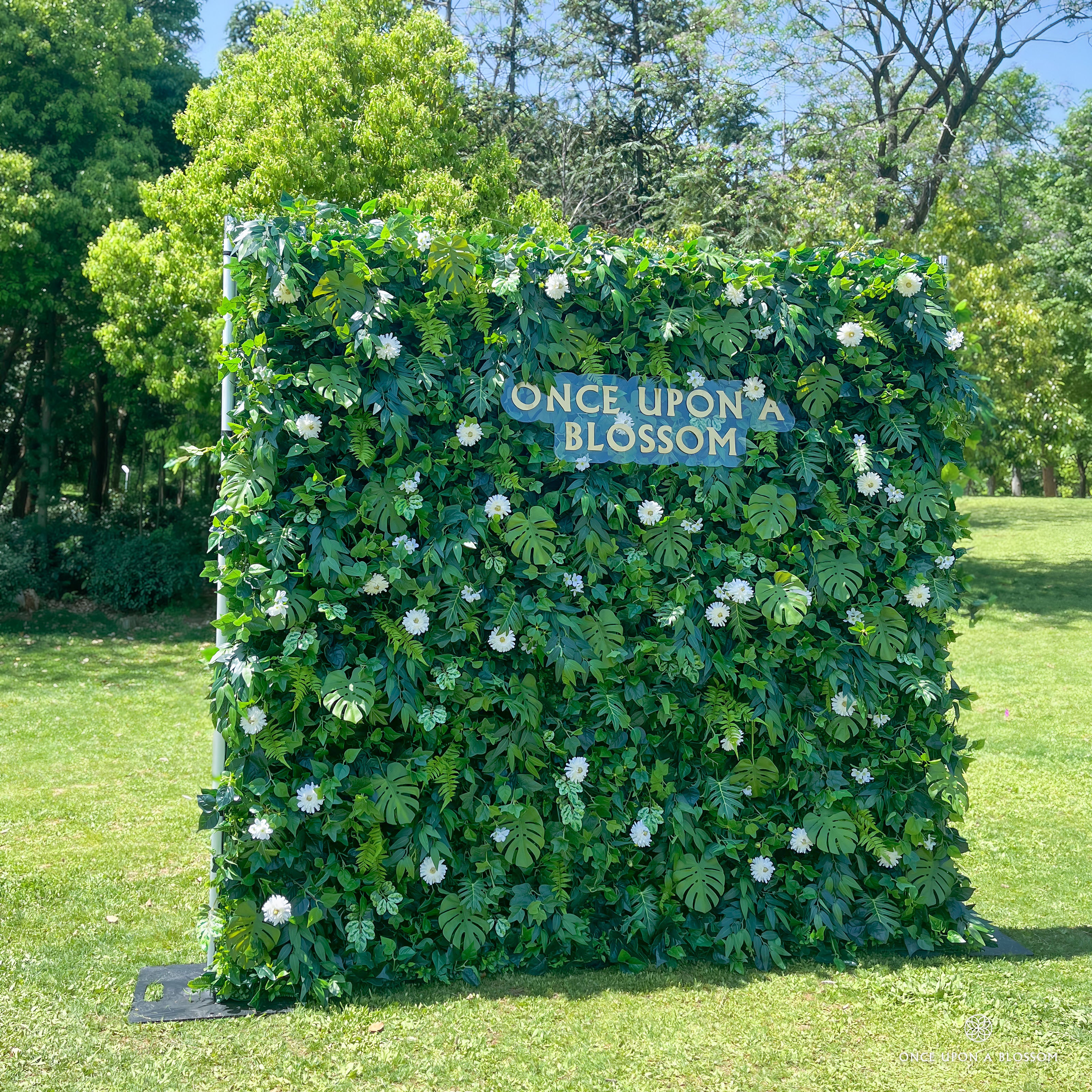 left-side angle of greenery wall featuring chrysanthemums, pothos, and monstera leaves, from our Pearl Garden.