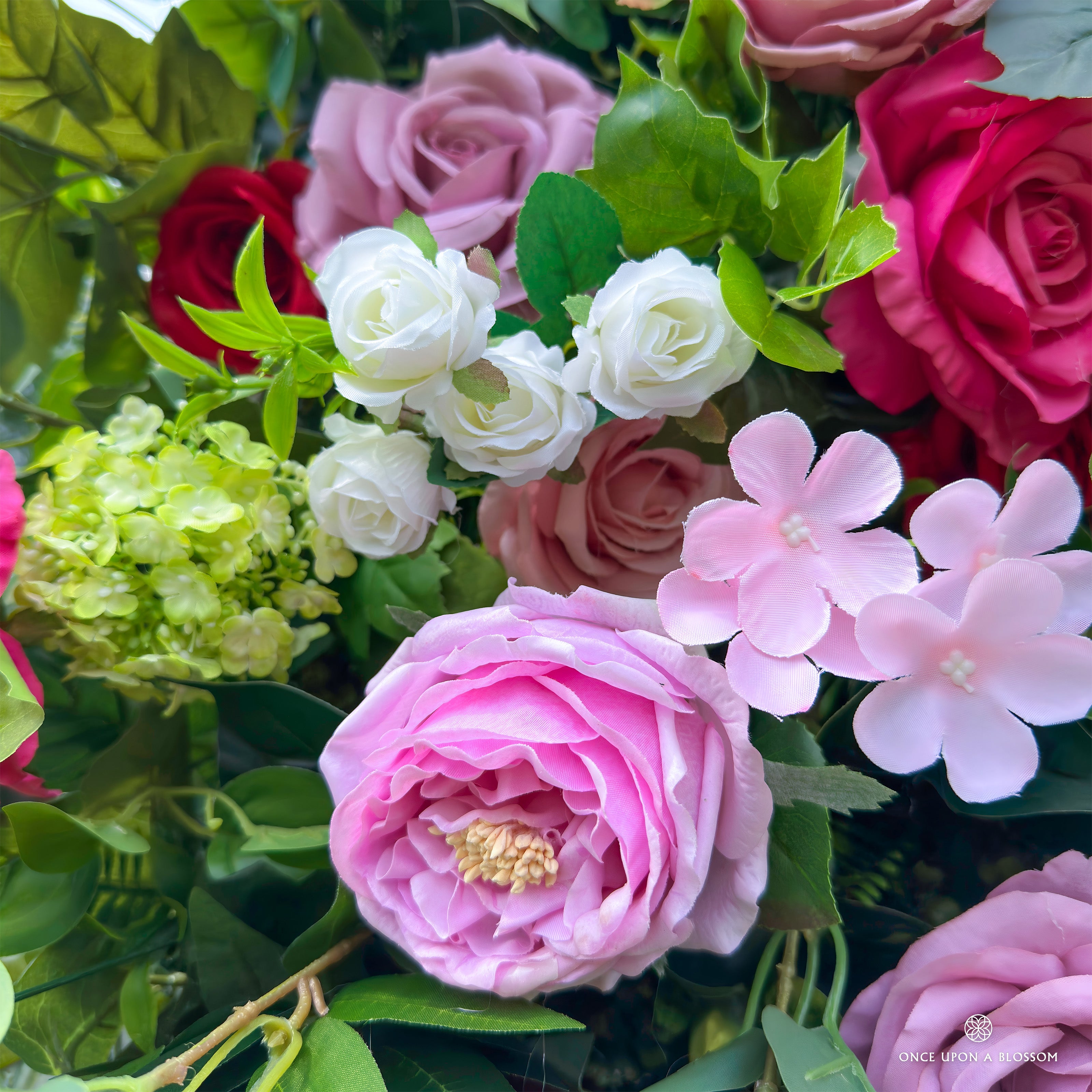 Detailed view of Summer Sangria with lifelike purple roses and greenery.