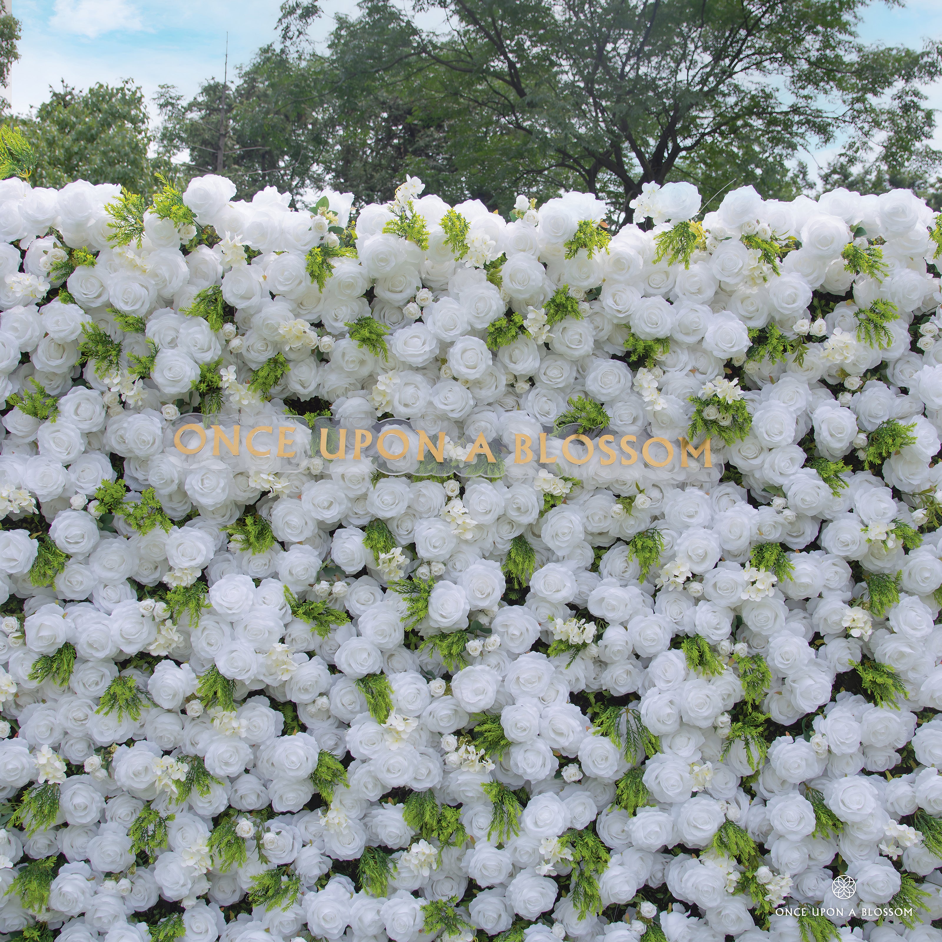 White flowers and greenery featured on Garden Party photo booth backdrop