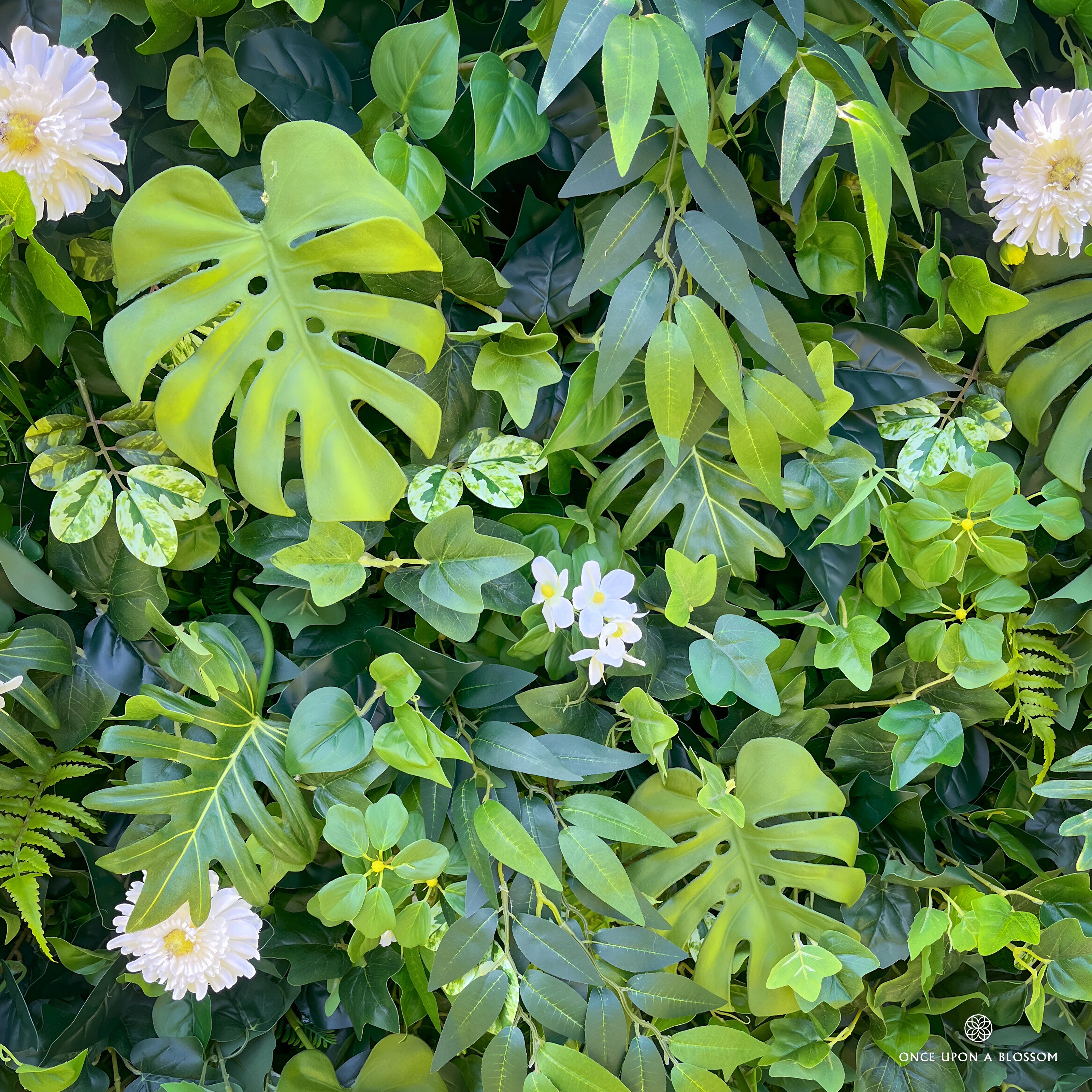 detail shot of petals and foliage of greenery wall featuring chrysanthemums, pothos, and monstera leaves, from our Pearl Garden.