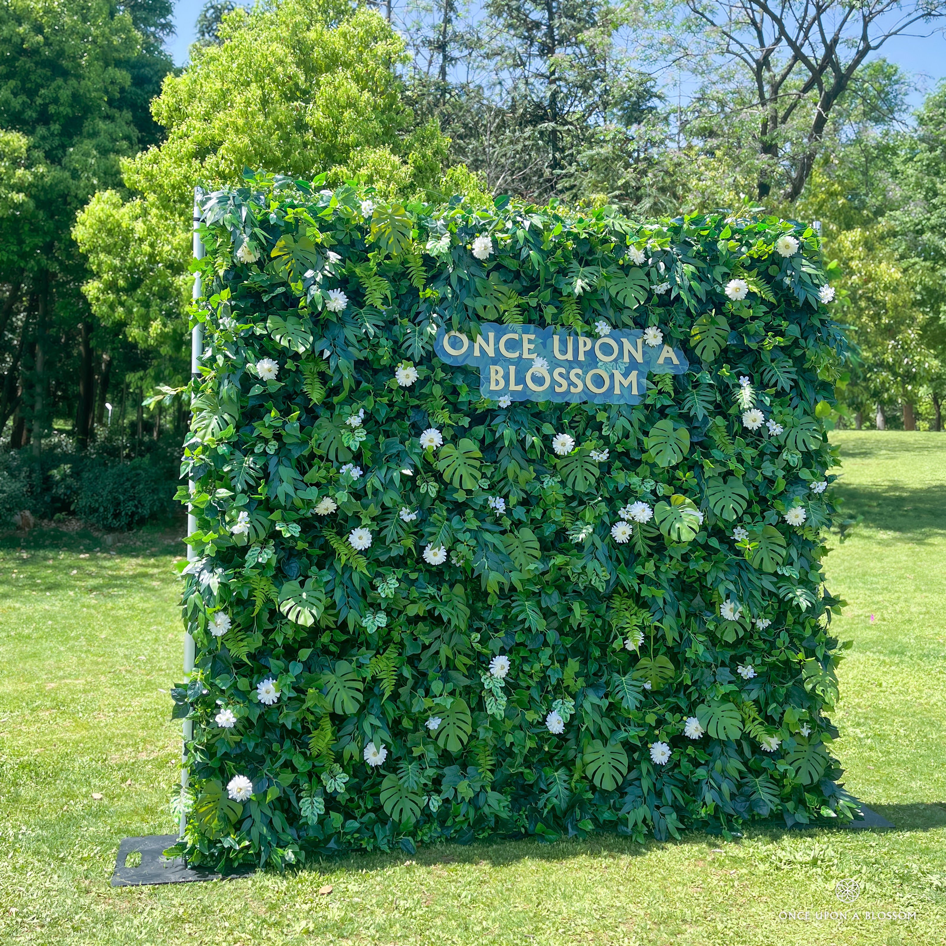 left-side angle of greenery wall featuring chrysanthemums, pothos, and monstera leaves, from our Pearl Garden.