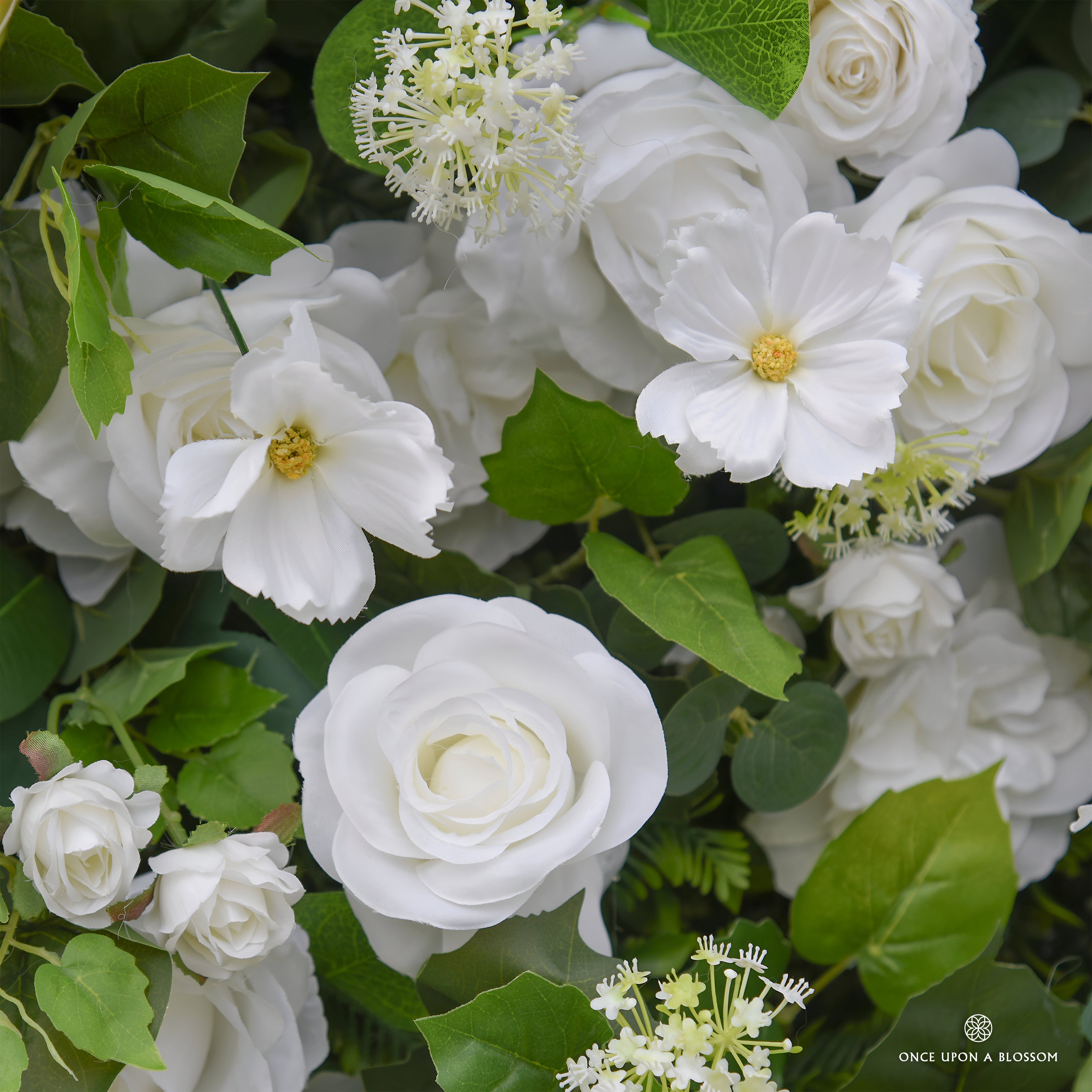 Close-up of white flowers with green leaves, featuring the brand 'Once Upon a Blossom'.