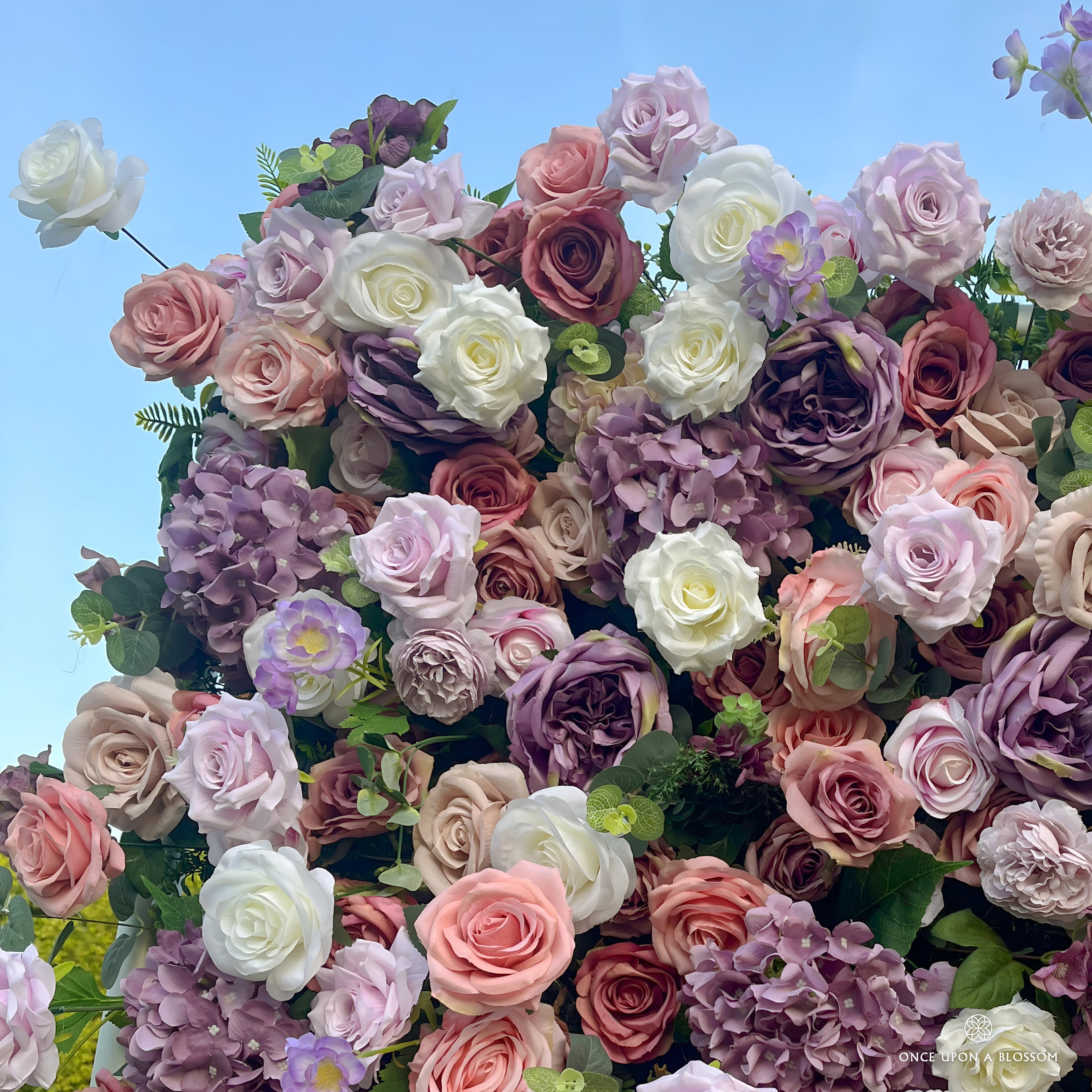 detail shot of petals and foliage of purple, pink, and white flower wall featuring roses, from our Purple Velvet.