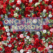 detail shot of petals and foliage of red, white, and green flower wall featuring roses and greenery, from our Ruby Rouge.