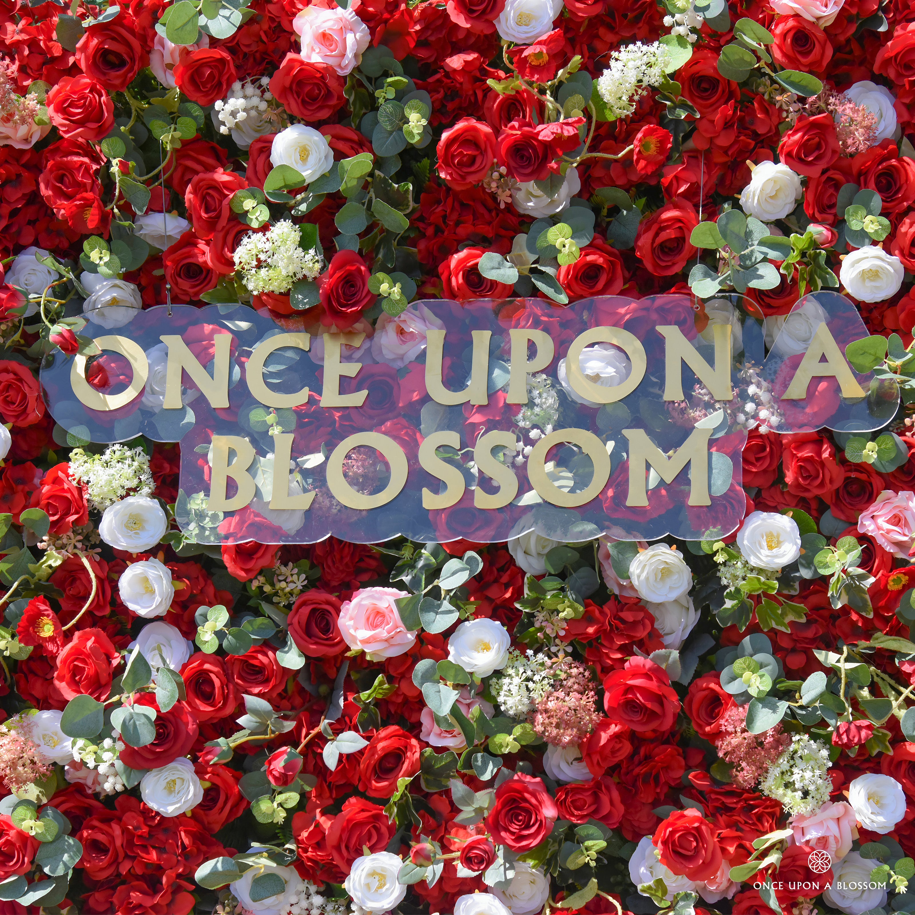 detail shot of petals and foliage of red, white, and green flower wall featuring roses and greenery, from our Ruby Rouge.