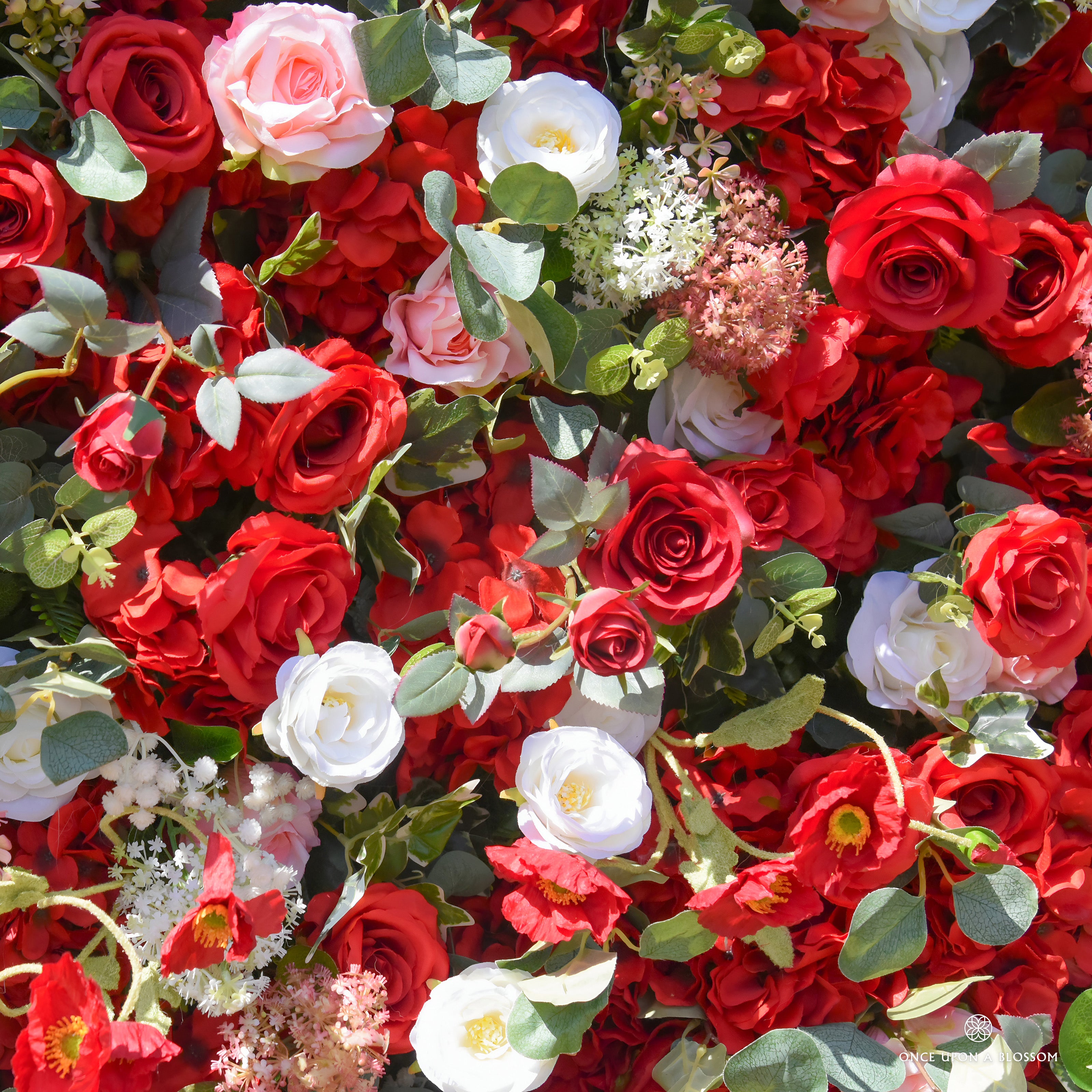 detail shot of petals and foliage of red, white, and green flower wall featuring roses and greenery, from our Ruby Rouge.