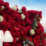 detail shot of petals and foliage of red and green flower wall featuring premium red roses, from our Lost Roses
