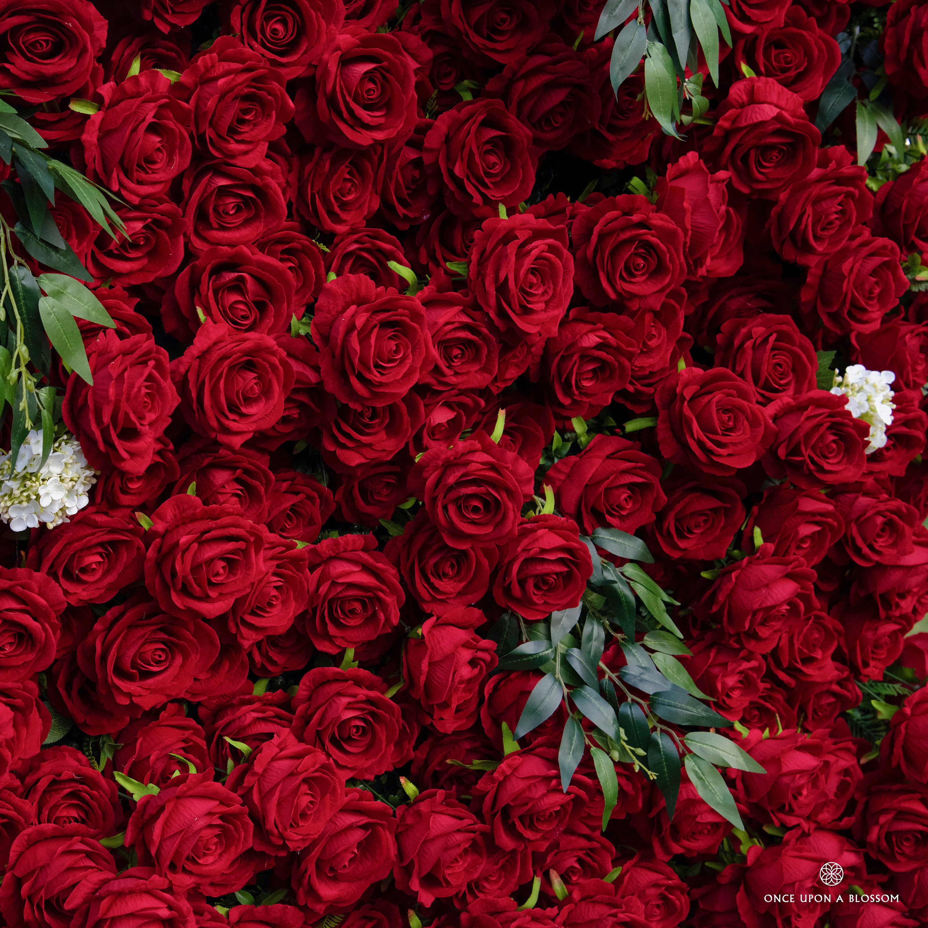 detail shot of petals and foliage of red and green flower wall featuring premium red roses, from our Lost Roses