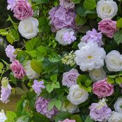 Wall of pink, white, and purple flowers with green leaves