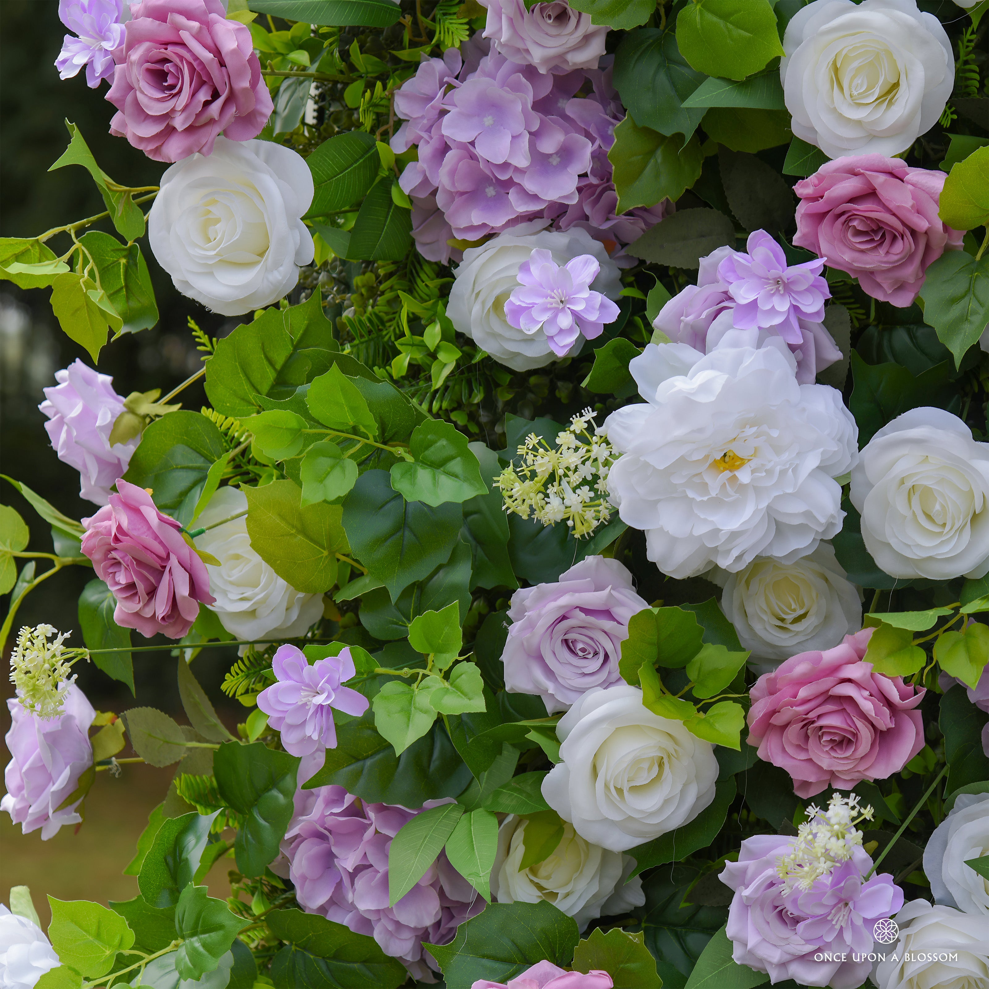 Wall of pink, white, and purple flowers with green leaves