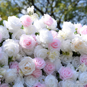 Close-up of light pink and white silk roses with small white blossoms on the Sweet Nothings flower wall