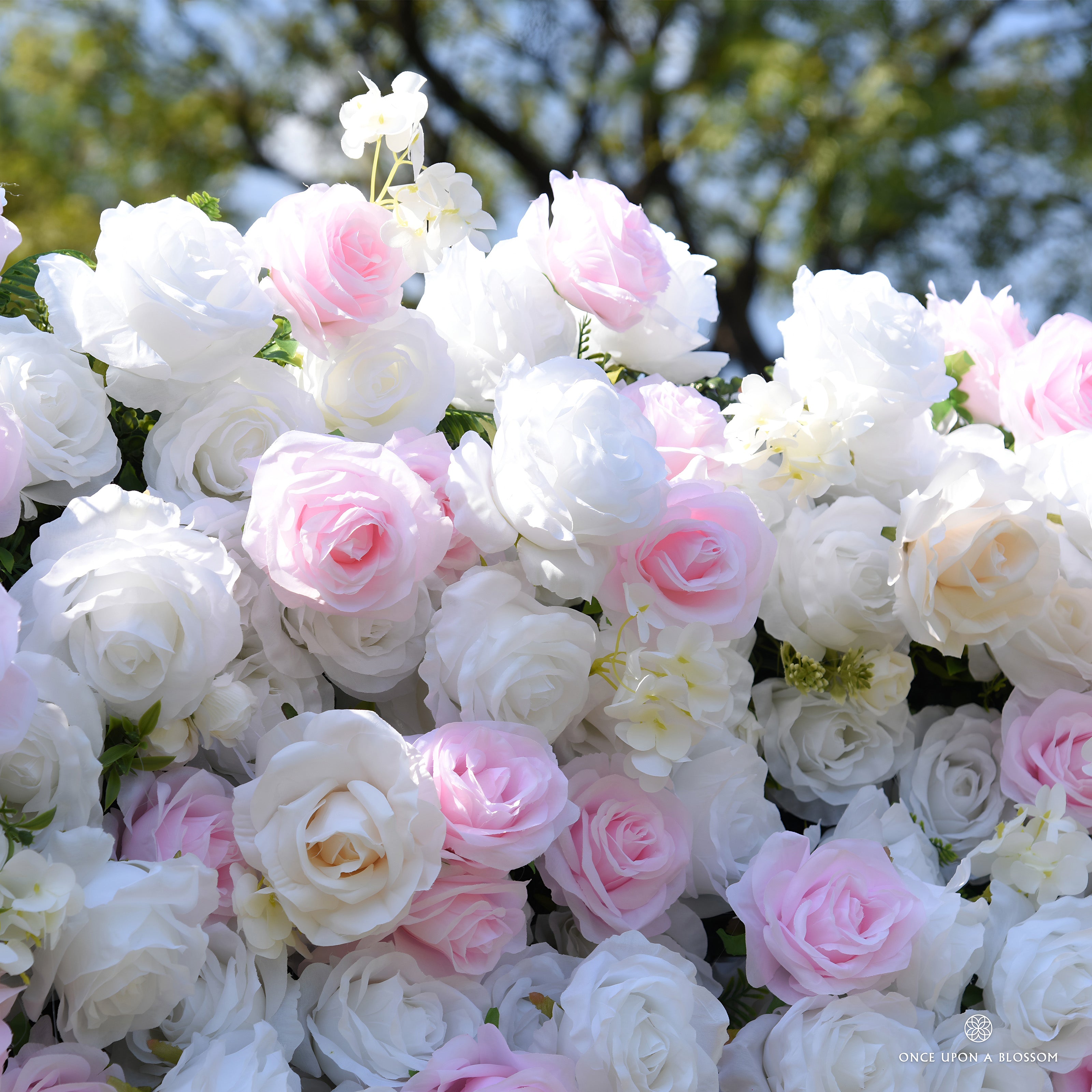 Close-up of light pink and white silk roses with small white blossoms on the Sweet Nothings flower wall