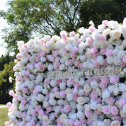Angled mid shot of the Sweet Nothings flower wall with the Once Upon a Blossom sign and light pink roses