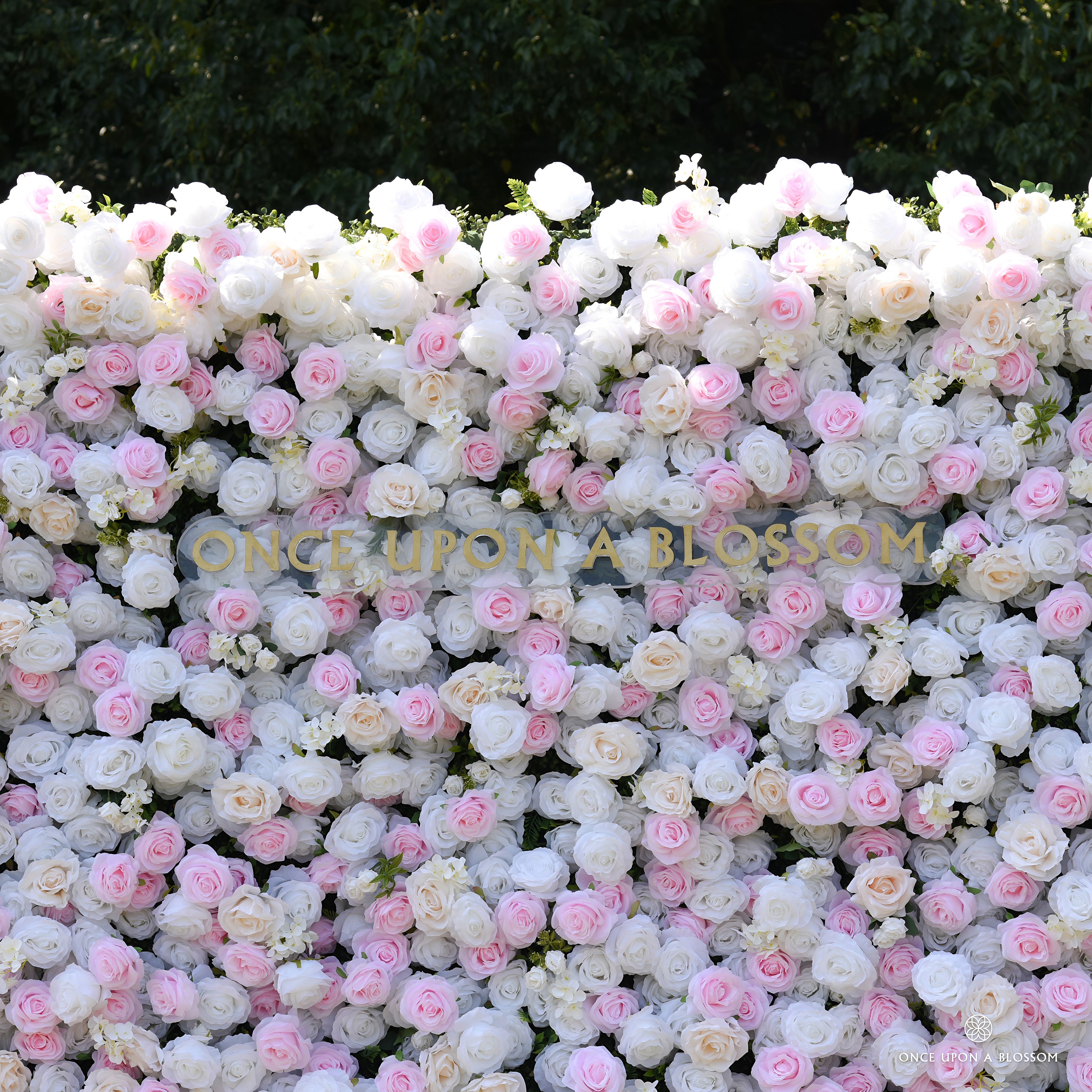 Mid shot of the Sweet Nothings pink and white flower wall, light pink roses scattered evenly through white blooms